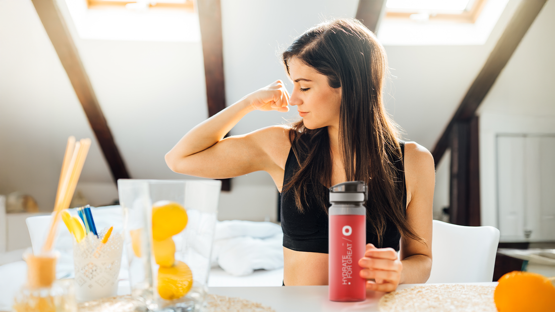 Kobieta z bidonem napinająca biceps