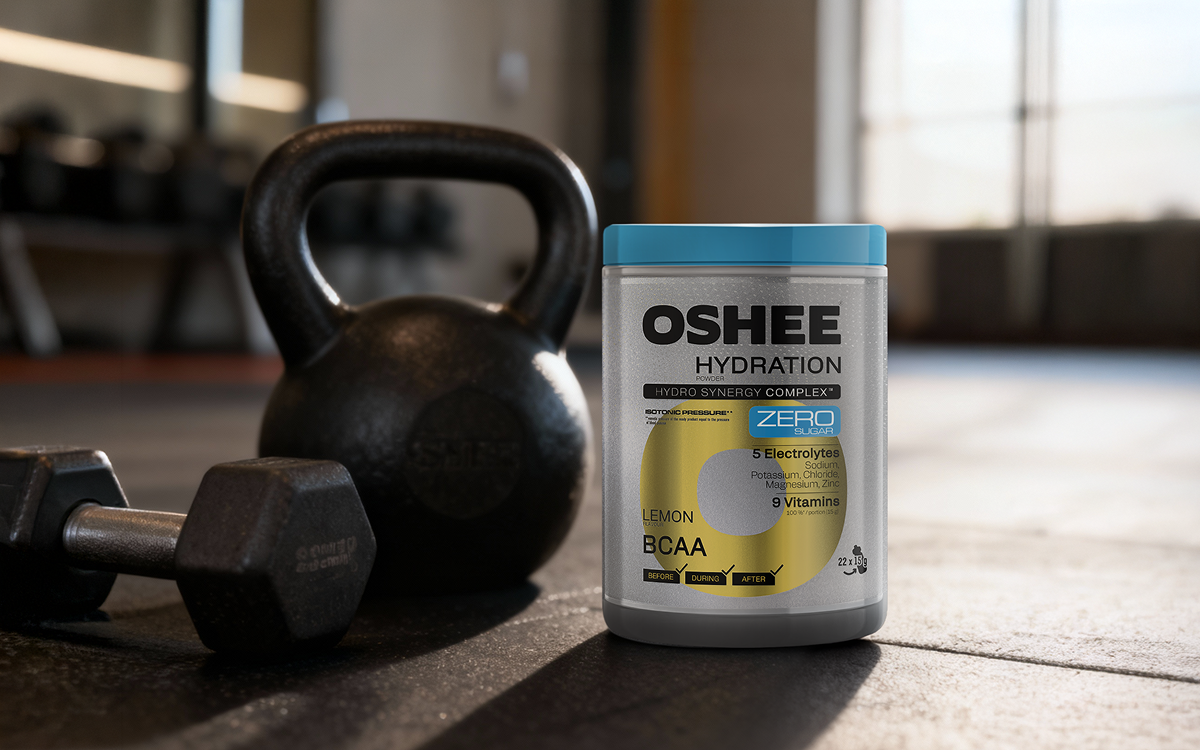 oshee lemon bcaa na tle siłowni, obok leżą ketle oraz hantle